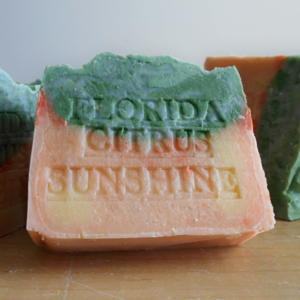 Bar of soap with 'Florida Citrus Sunshine' text on a wooden surface