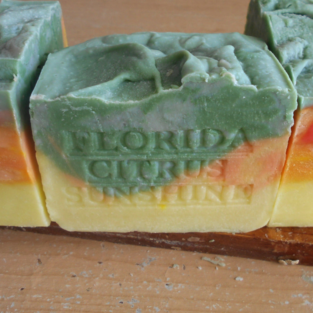 Colorful soap bars with 'Florida Citrus Sunray' branding on a wooden surface