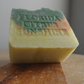 Bar of soap with 'Florida Citrus  Sunshine'  stamp  branding on a wooden surface.