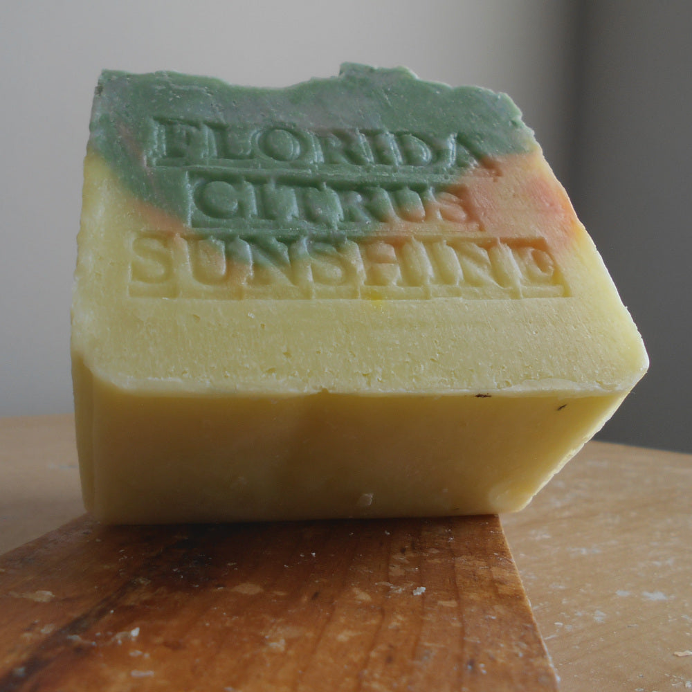 Bar of soap with 'Florida Citrus  Sunshine'  stamp  branding on a wooden surface.