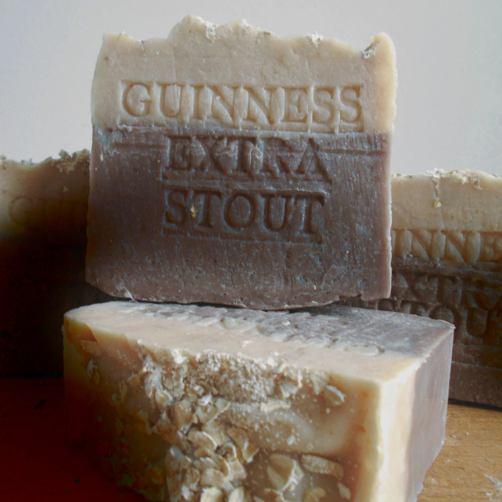 Bar of Guinness Extra Stout soap with visible branding on a wooden surface.