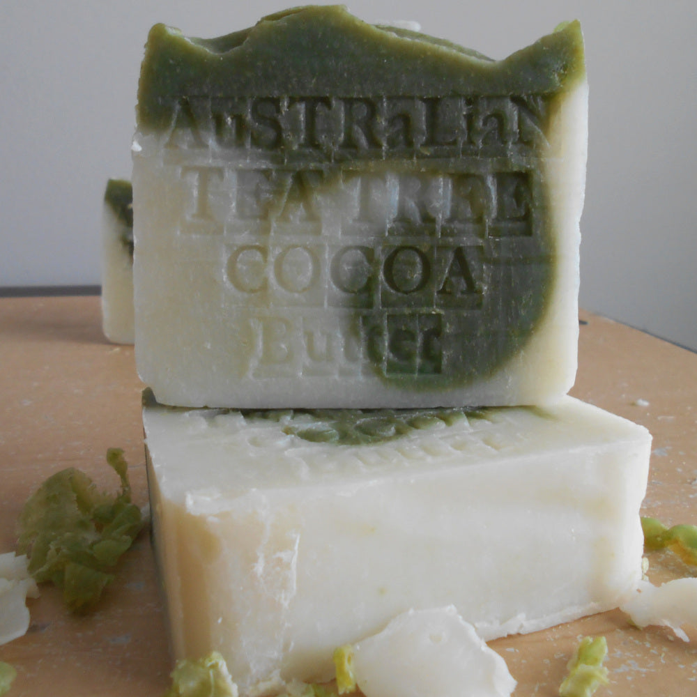 Two bars of soap with 'Australian Leather Cocoa Butter' branding on a wooden surface.