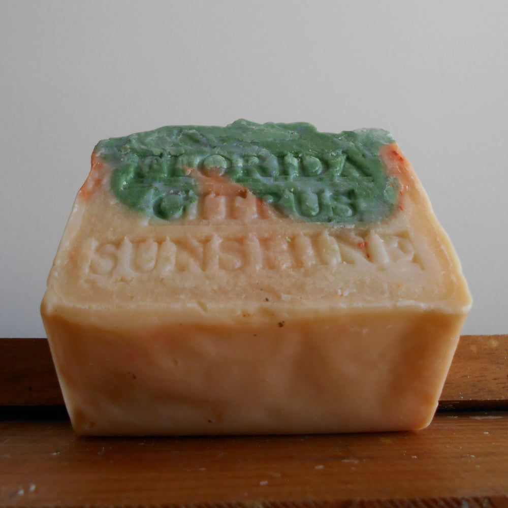 Bar of soap with 'World's Florida Citrus Sunshine ' text on a wooden surface