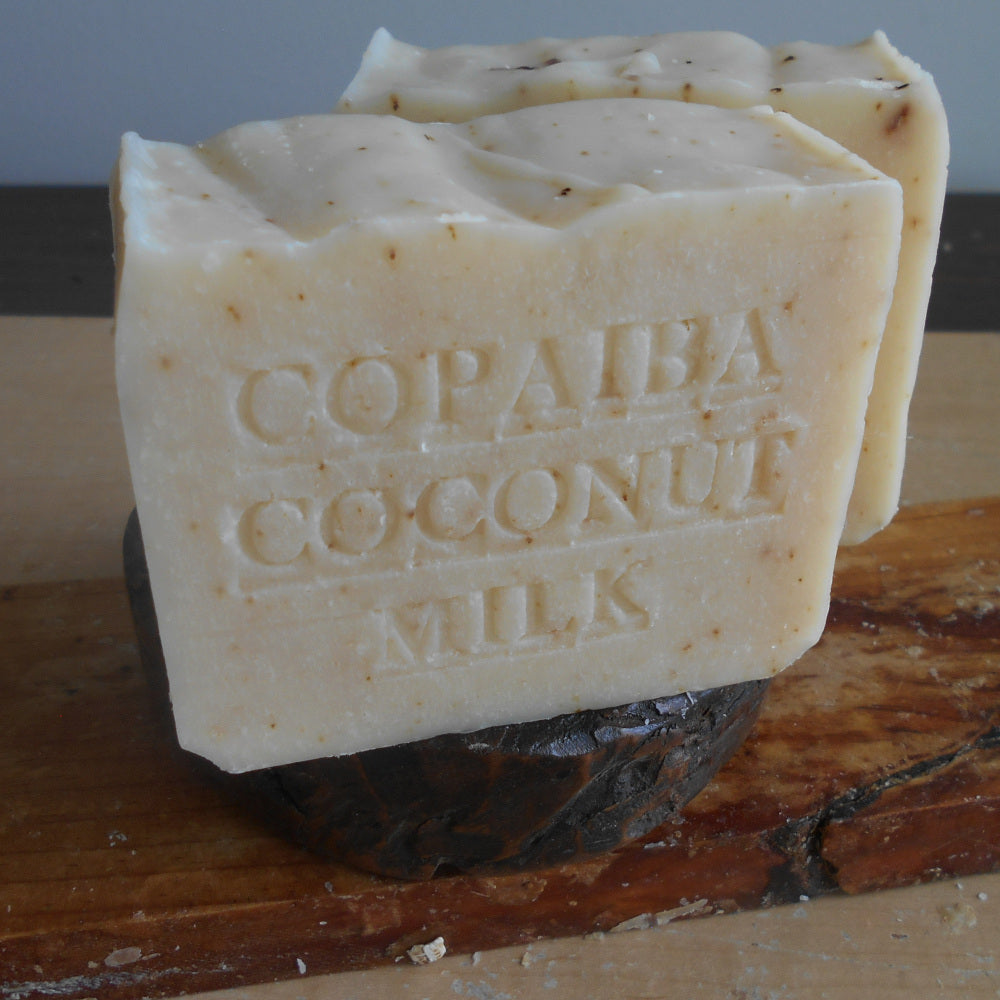 Bar of soap labeled 'Copaiba Coconut Milk' on a wooden surface