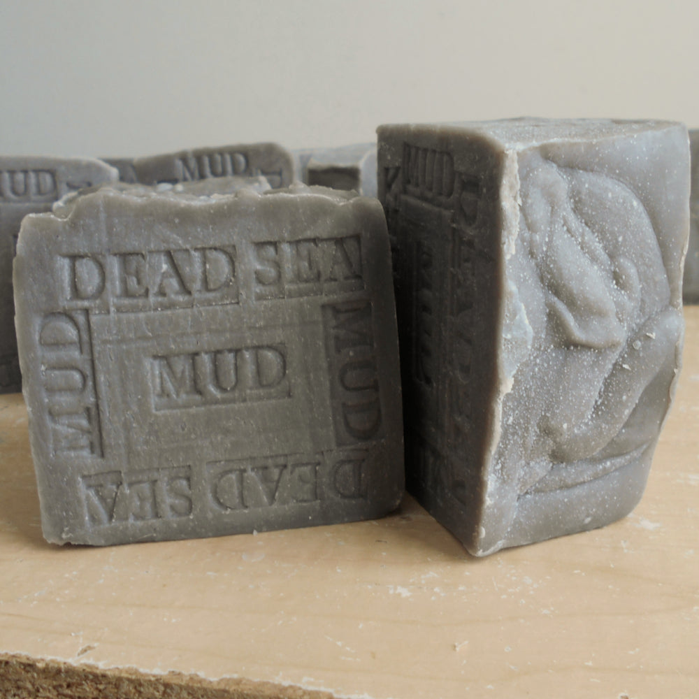Soap bars with embossed text reading 'DEAD SEA MUD' and 'MUD DEAD SEA' 