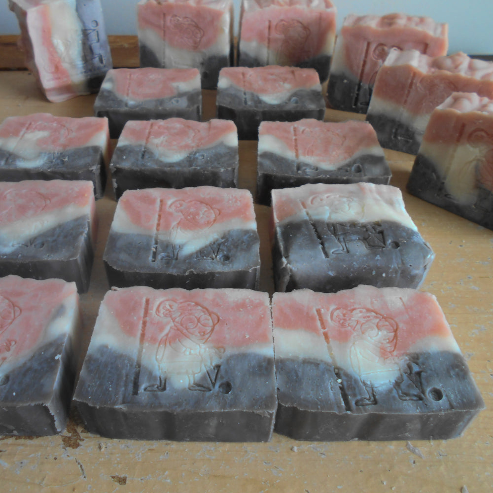 Stack of layered soap bars with pink  , white and gray colors  with a  Grandma's Logo stamp
