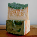 Two bars of soap with 'Florida Citrus Sunshine' text on a wooden surface.