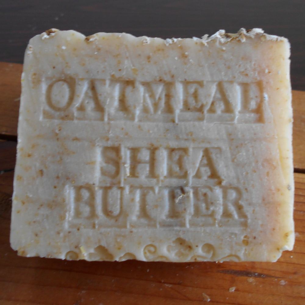 Bar of soap with 'Oatmeal Shea Butter' text on a wooden surface
