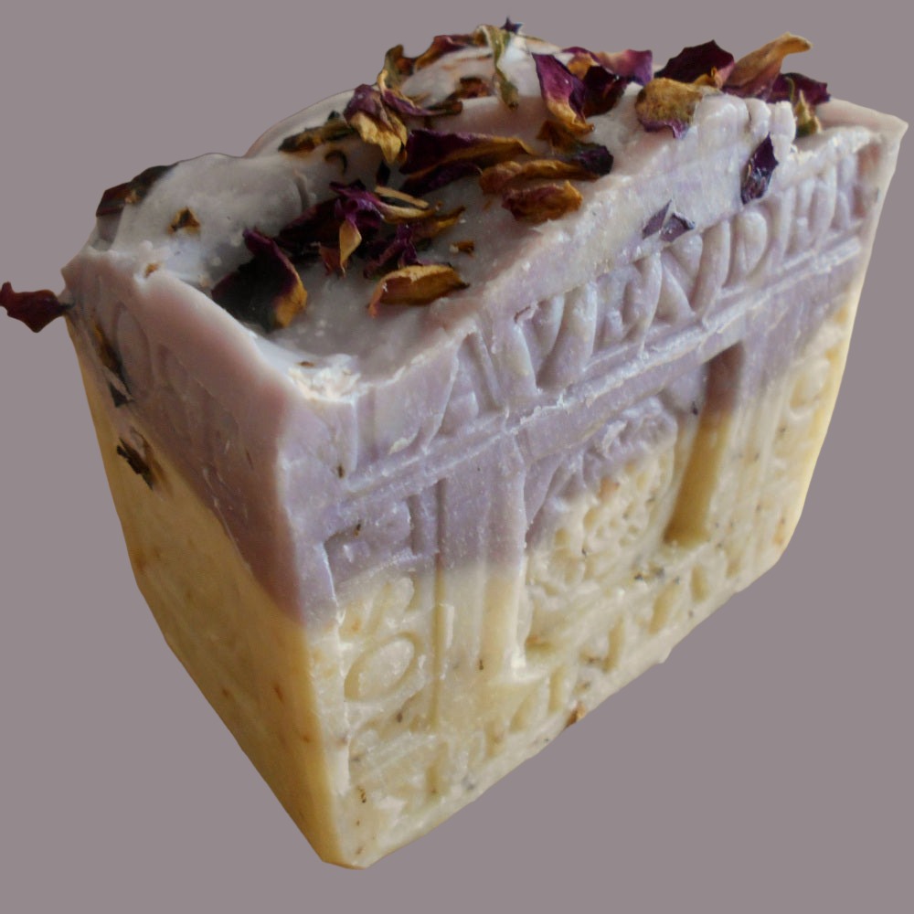 The soap is a mix of white and light purple, with the word "LAVENDER" visibly embossed on a bar, rustic appearance