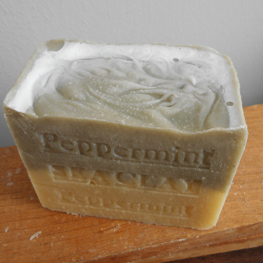 A bar of peppermint soap with sea clay aged, with visible stamped text on the surface.